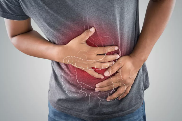 Person clutching their stomach with a red glow over the abdomen, indicating abdominal pain or cramps.